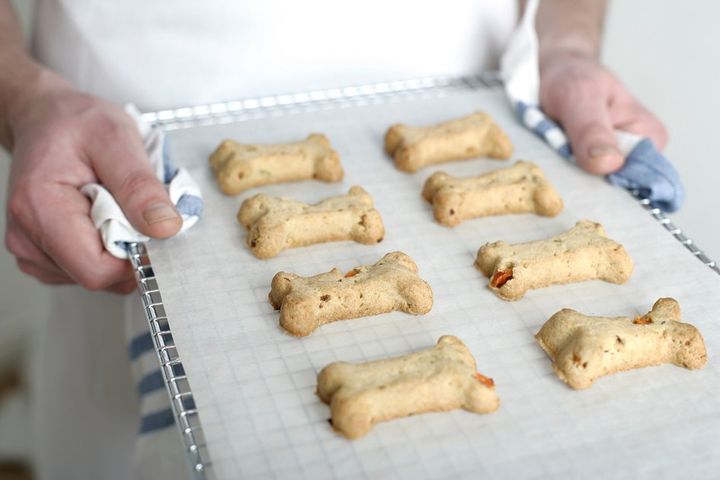 Dog treats being carried on a tray after they have been baked